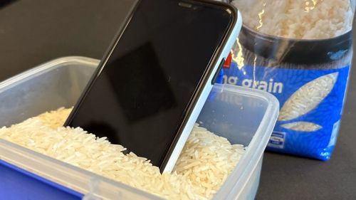 A water-damaged phone in a container of rice