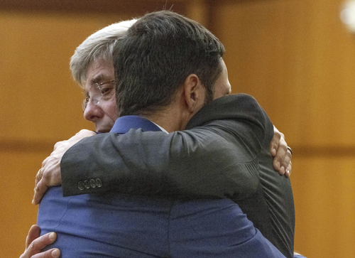 Tacoma Police officer Christopher Burbank getting a hug from his attorney Wayne Fricke.