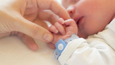 Baby boy wearing hospital bracelet, newborn
