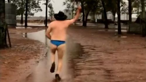 One man celebrates the downpour with vigour.