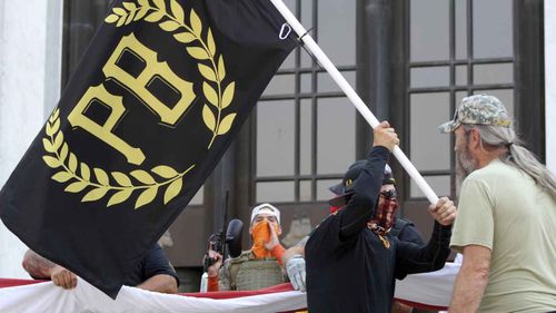 A protester carries a Proud Boys banner in Salem, Oregon.