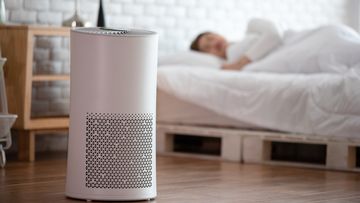 woman sleep with Air purifier in cozy white bed room for filter and cleaning removing dust PM2.5 HEPA in home,for fresh air and healthy life,Air Pollution Concept