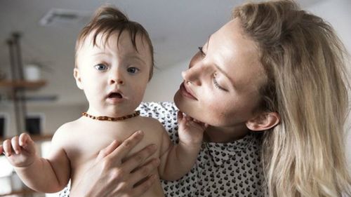 Beautiful baby with Down syndrome loves the camera as much as his model mum