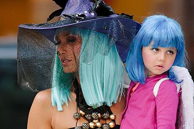 Cookbook celeb Padma Lakshmi wears a green wig and witch’s hat as she clutches daughter Krishna in an angel-winged Halloween costume in New York City.