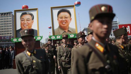 Soldiers carry photos of Kim Il-Sung and Kim Jong-Il during a parade last year. (AAP)