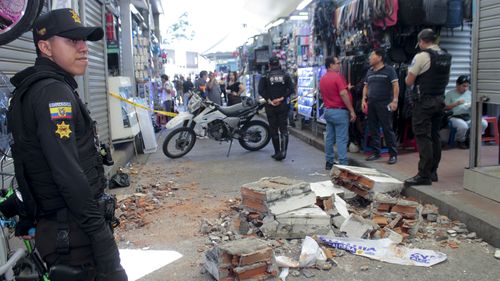 Police basal   by debris fallen from a gathering  astatine  a commercialized  country  aft  an earthquake shook Machala, Ecuador, Saturday, March 18, 2023. 