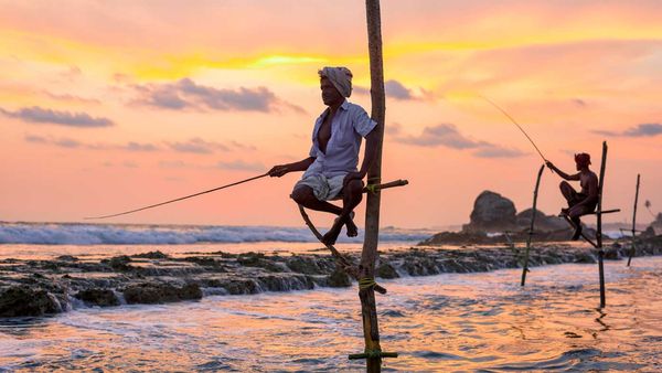 Traditional fishermen work as the sun sets near Galle.