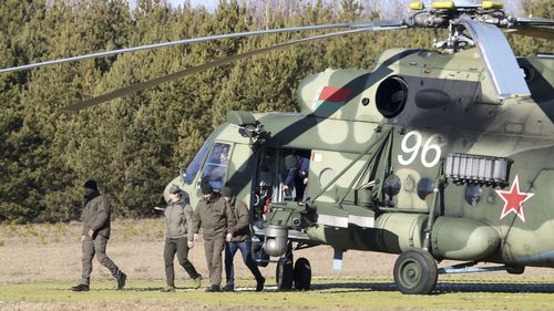 The Ukrainian delegation leaves a Belarusian military helicopter upon their landing in Gomel region, Belarus.
