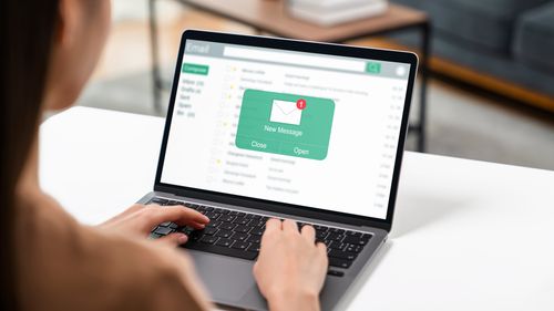 Donna che utilizza il computer sul tavolo con un nuovo messaggio e-mail sul laptop, messaggio di connessione di comunicazione alle lettere globali sul posto di lavoro