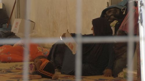  A woman and a small child lie on the floor of a tent in a camp for displaced people on the outskirts of Mosul, Iraq. (GETTY)