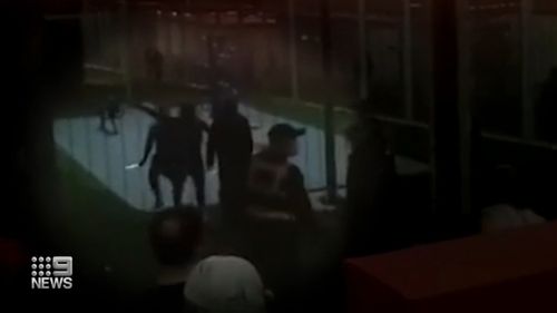 Recordings show one detainee swinging a weapon while another is being led away by the security guard before the riot crew beats two inmates. 