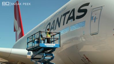 Qantas worker works on a plane