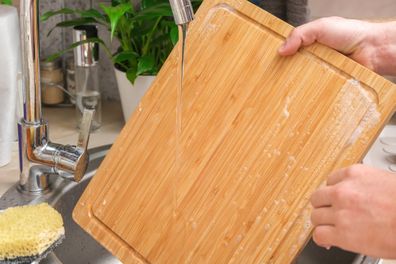 Washing a wooden cutting board in the sink