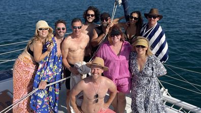 Shelly Horton Christmas party. Group gathered on boat, smiling for the camera, huddled together.