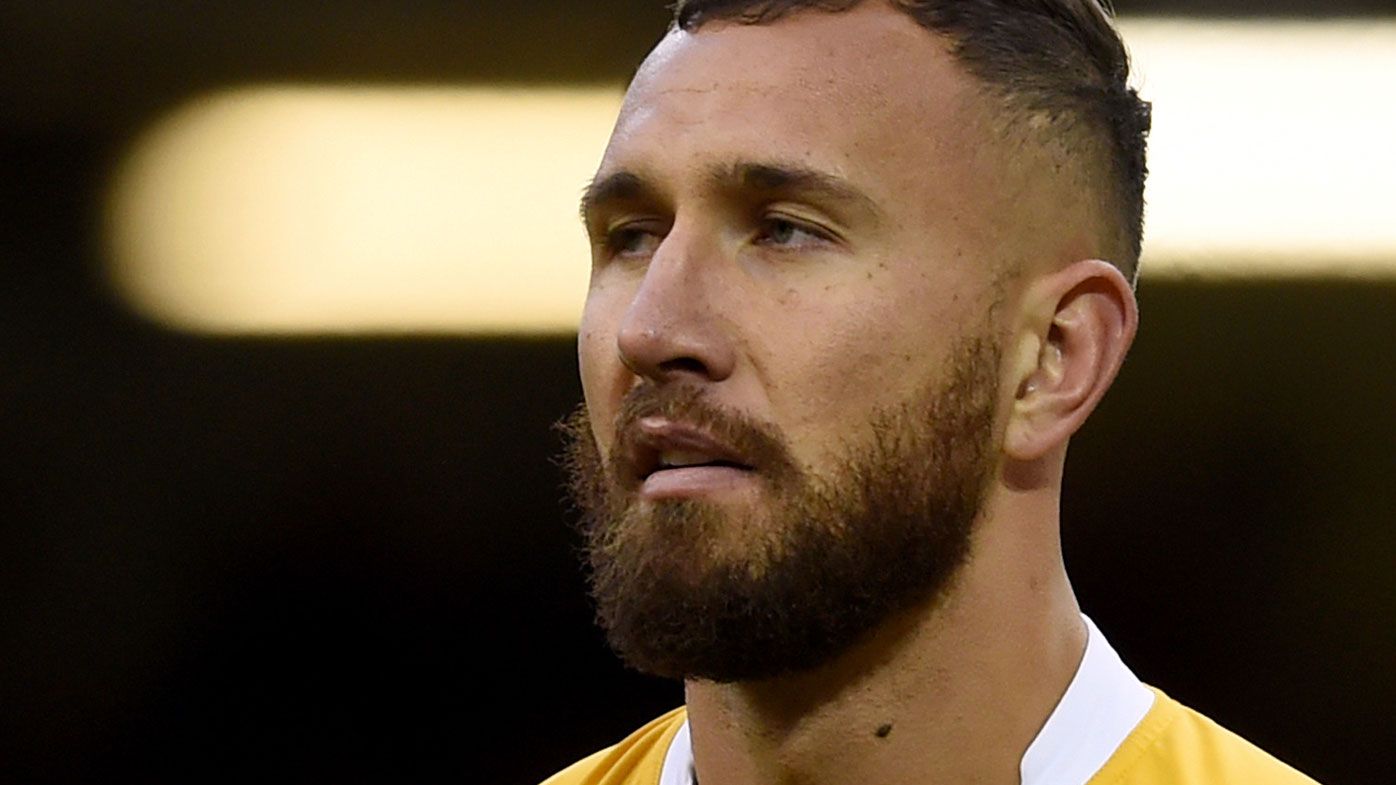 Quade Cooper is content to warm the bench for the Wallabies. (AAP)