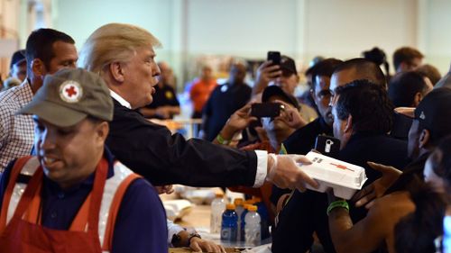 US President Donald Trump serves food to Hurricane Harvey victims at NRG Center in Houston on September 2, 2017.&nbsp;(AFP)