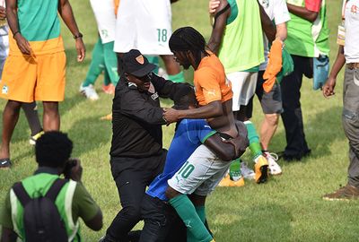 A policeman attempts to drag a fan off star Gervinho.