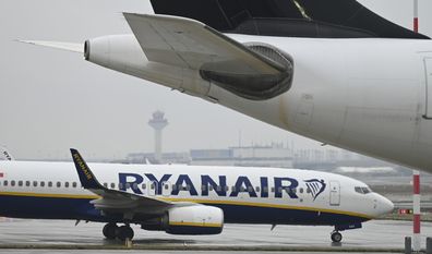 A Ryanair Boeing 737-8AS taxis past another aircraft on the apron at Frankfurt Airport in Frankfurt, Berlin, Friday, Jan. 7, 2022. Budget airline Ryanair says it will stop serving Germanys busiest airport at the end of March and close its base there. Ryanair said Friday, Jan. 7, 2022 that it's reallocating five planes it has based at Frankfurt Airport to other European airports that have responded with lower airport charges to stimulate traffic recovery. (Arne Dedert/dpa via AP)