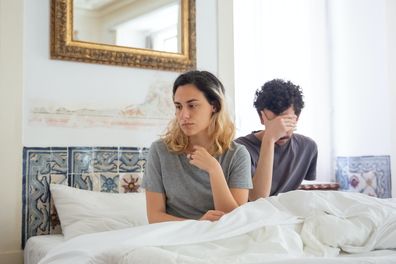 Unhappy couple in bed together