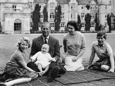 In this 1960 photo, Queen Elizabeth, Prince Philip and their children, Prince Charles,  Princess Anne and Prince Andrew sit on the lawn of Balmoral Castle