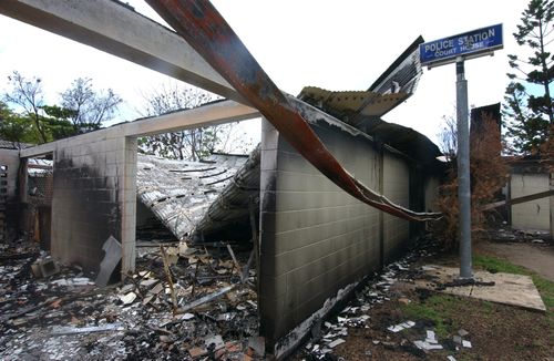 The burn-out remains of the local police station after angry rioters set it ablaze with police officers still inside. (AAP)