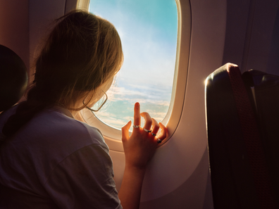 Woman looking out a plane window
