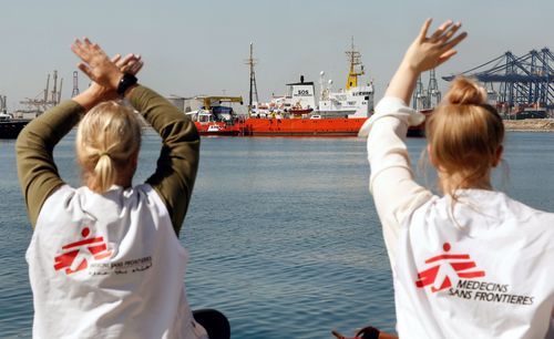 Two women wearing shirts of the relief organization 'Medecins Sans Frontieres' wave to people on the Aquarius. Picture: AP