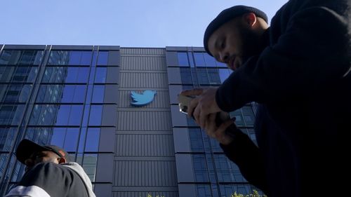 People walk outside Twitter headquarters in San Francisco, Friday, Nov. 4, 2022. 