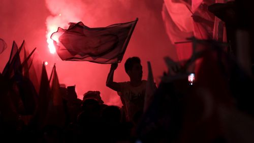 Supporters of Turkish President Recep Tayyip Erdogan celebrate after the close of voting for the Turkish presidential and parliamentary elections in Istanbul. (AP).