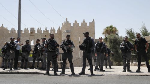 Heavily armed officers guard the sacred site following the shooting. 