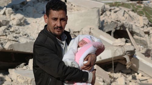 Khalil al-Sawadi holds Afraa, a baby girl who was born under the rubble caused by an earthquake that hit Syria and Turkey, in the town of Jinderis, Aleppo province, Syria.