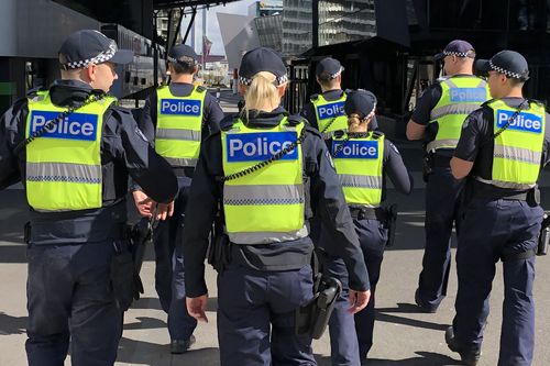 A group of uniformed members of Victoria Police on patrol.