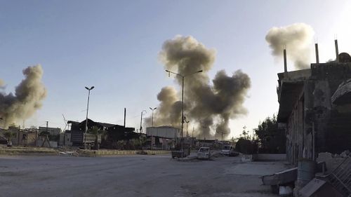 A photo released by the Syrian Civil Defense White Helmets shows smoke rising after Syrian government airstrikes hit in the town of Douma. (AP/AAP)