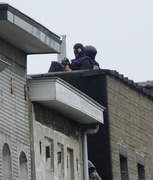 Snipers stand at rue Delaunoy during highly-targeted raids in the district of Molenbeek, Brussels. (AAP)