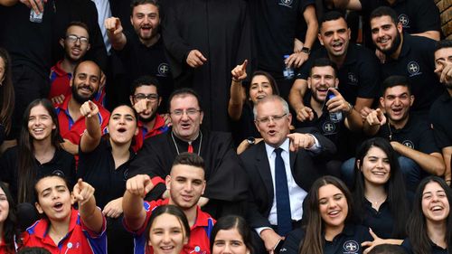 Prime Minister Scott Morrison and Bishop Antoine-Charbel Tarabay with young parishoners after Good Friday Easter services at St Charbel's Catholic Maronite Church at Punchbowl.