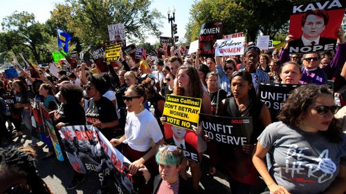 Protesters march toward the Supreme Court as they demonstrate against Supreme Court nominee Brett Kavanaugh.
