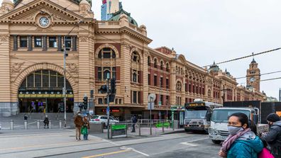 Pedestrians wearing masks outside Flinders Street station in Melbourne.