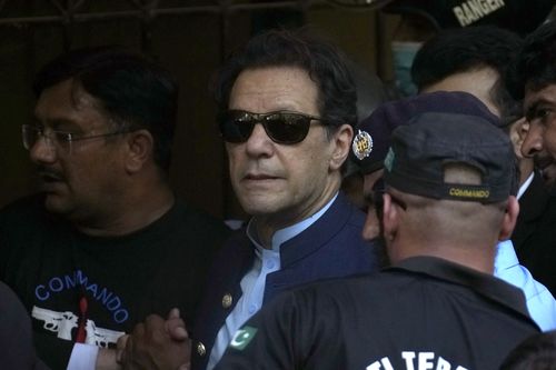Pakistan's former Prime Minister Imran Khan, centre, is escorted by security officials as he arrive to appear in a court, in Islamabad, Pakistan, Friday, May 12, 2023.  