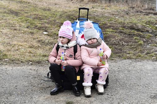 Sisters wait at a checkpoint run by local volunteers after arriving from Ukraine, crossing the border in Beregsurany, Hungary, Saturday, Feb 26, 2022. Hungary has extended legal protection to those fleeing the Russian invasion. (AP Photo/Anna Szilagyi)