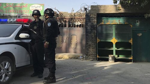 Police officers on duty in the vicinity of a centre believed to be used for re-education in Korla in western China's Xinjiang region.