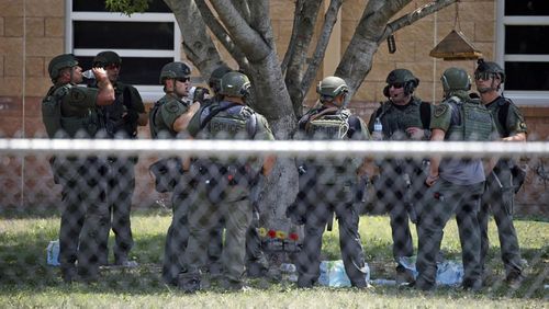   Law enforcement personnel stand outside Robb Elementary School following a shooting, May 24, 2022, in Uvalde, Texas. 
