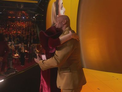 Adele hugs The Rock after winning a Grammy at the 2023 awards.