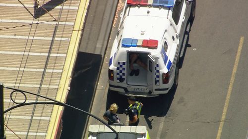 The alleged offender was loaded into a divvy van at the scene.