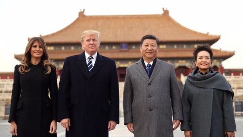 President Donald Trump, second left, first lady Melania Trump, left, Chinese President Xi Jinping, second right, and his wife Peng Liyuan, right, stand together as they tour the Forbidden City. (AAP)