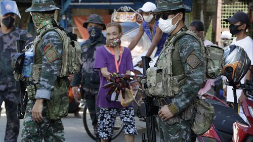 Police officers operate a checkpoint during the start of a lockdown due to a rise in COVID cases in the city of Navotas, Manila, Philippines.