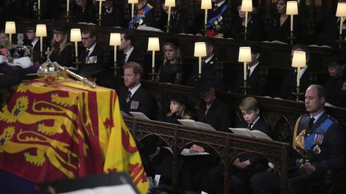 From left, Prince Harry, the Duke of Sussex, Princess Charlotte, Kate the Princess of Wales, Prince George and Prince William sit, during the committal service for Queen Elizabeth II, at St. George's Chapel, in Windsor, England, Monday Sept. 19, 2022. 
