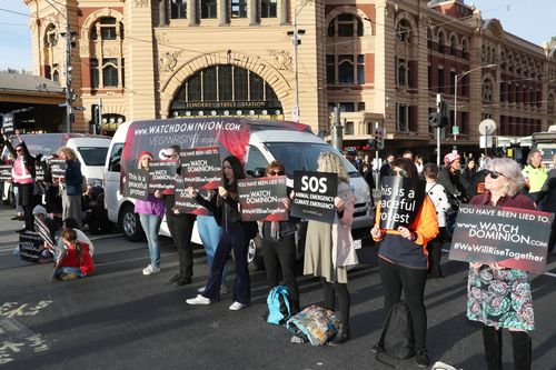 Animal rights protesters block the intersections of Flinders and Swanston Street during early morning traffic in Melbourne.