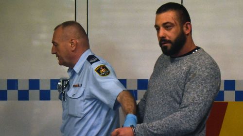 Ricardo Barbaro is escorted to a prison van at Burwood Court in Sydney.