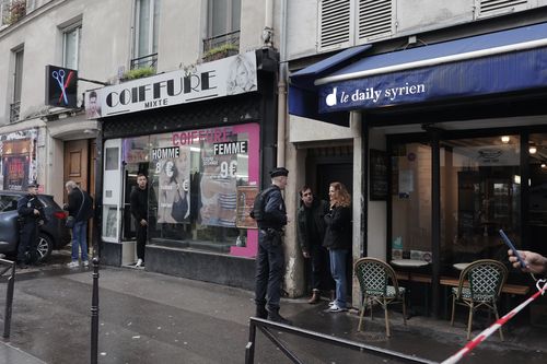 Police officers investigate the scene where a shooting took place in Paris, Friday, Dec. 23, 2022.  