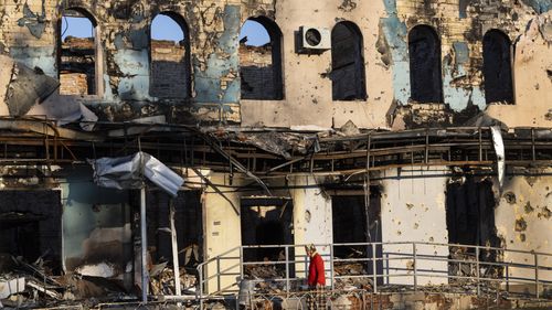 A woman walks by a destroyed building on September 23, 2022 in Izium, Ukraine. In recent weeks, Ukrainian forces have reclaimed villages east and south of Kharkiv, as Russian forces have withdrawn from areas they've occupied since early in the war.  (Photo by Paula Bronstein/Getty Images)